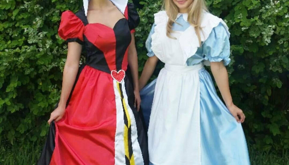 Two women dressed in colorful cosplay costumes standing outdoors.